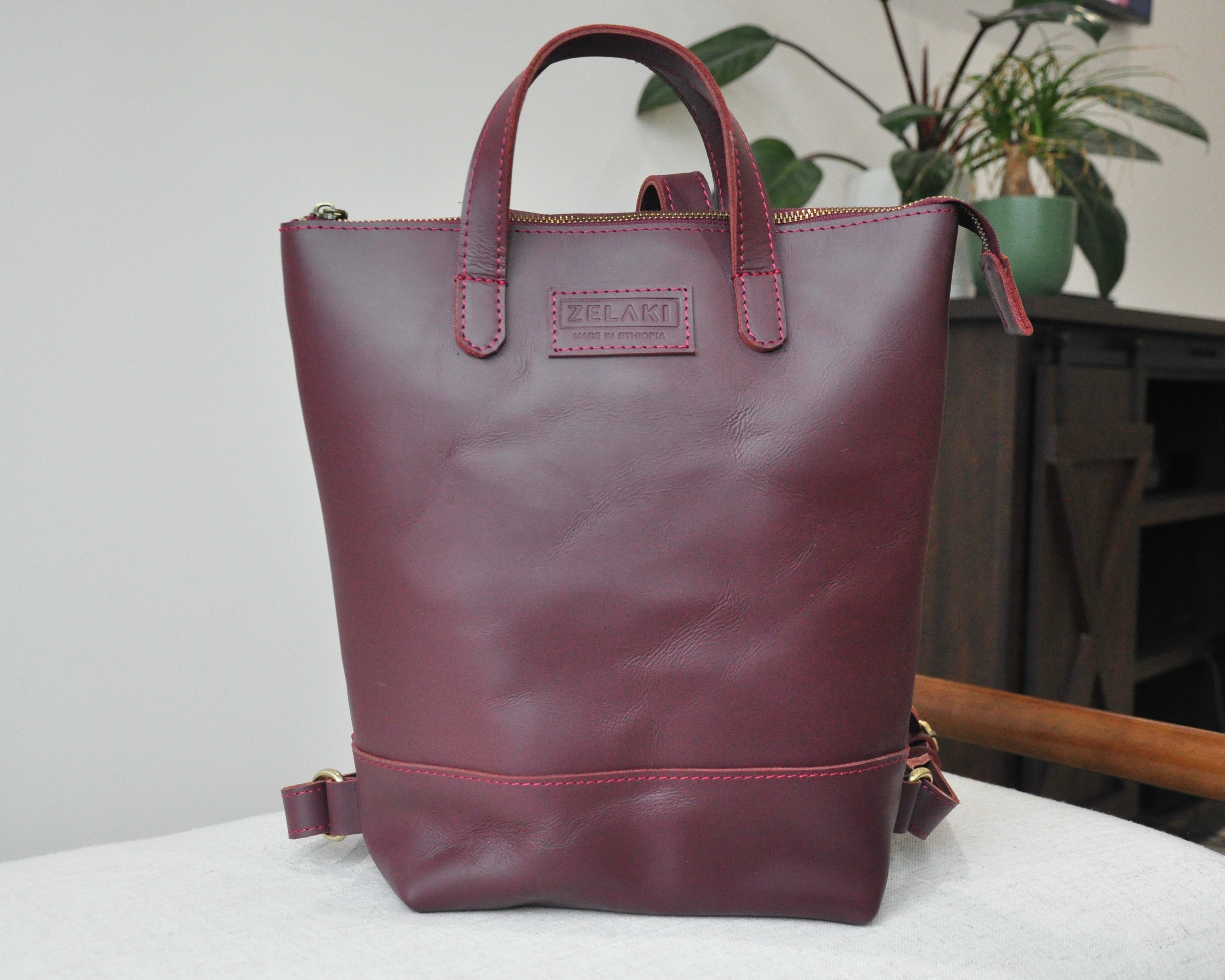 Small, burgundy, genuine full-grain leather backpack for women with zipper, durable and handmade in Ethiopia