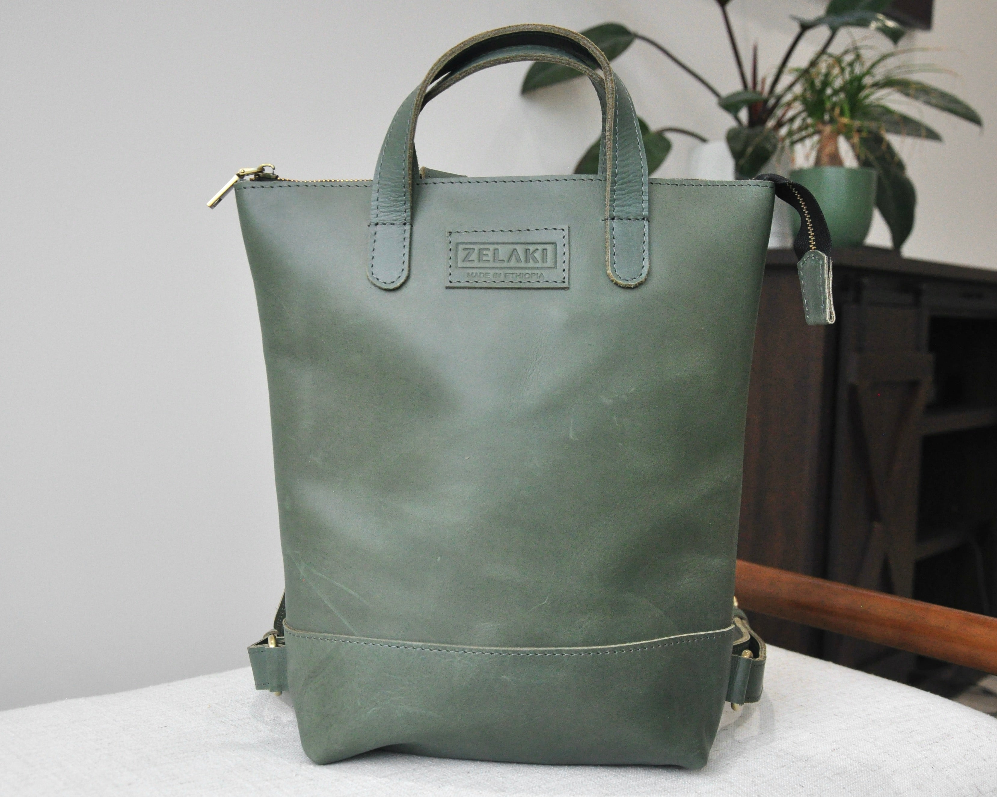 Small, olive green, genuine full-grain leather backpack for women with zipper, durable and handmade in Ethiopia